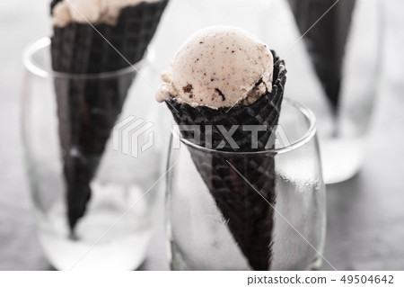 Black cone, waffle cup with ice cream, ice cream in a black cone and glass. Black cone, waffle cup with ice cream, ice cream in a black cone and glass. 49504642