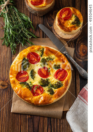 Vegetable pie with broccoli, peas, thyme. tomatoes and cheese on wooden background. Copy space. Vegetable pie with broccoli, peas, thyme. tomatoes and cheese on wooden background. Copy space. 49504645