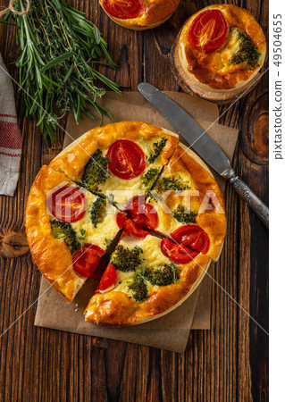 Vegetable pie with broccoli, peas, thyme. tomatoes and cheese on wooden background. Copy space. 49504655