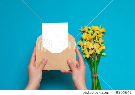 female hands holding craft envelope with a card, 49505641