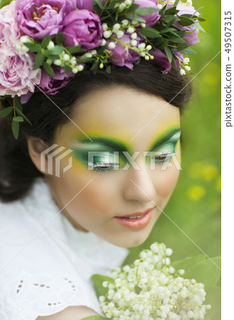 Portrait of a young girl with lily of the valley 49507315
