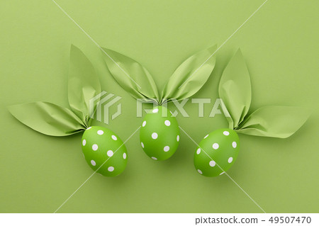 Green dotted Easter eggs with paper bunny ears 49507470