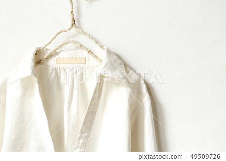 Upper body of a white hemp blouse on a hanger Upper body of a white hemp blouse on a hanger 49509726