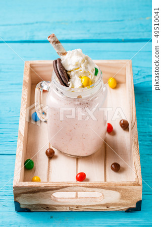 Fresh strawberry milkshakes on blue table. 49510041