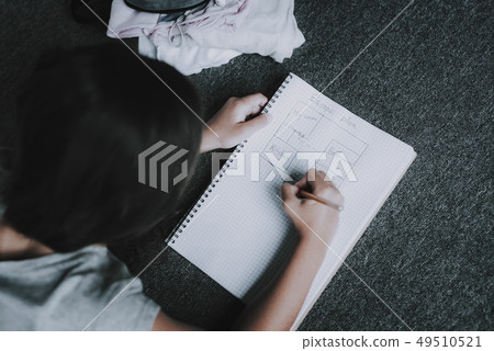 Girl Draw Escape Plan. Girl Lies on Gray Pillow. 49510521