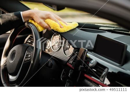 Cleaning car. Hand with microfiber cloth cleaning car interior 49511111