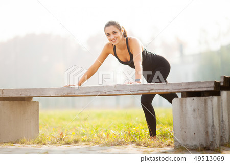 Portrait of beautiful sporty woman 20s in sportswear doing push-ups, and listening to music with 49513069