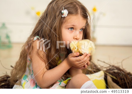 Beautiful little girl kisses a cute fluffy Easter Beautiful little girl kisses a cute fluffy Easter 49513319