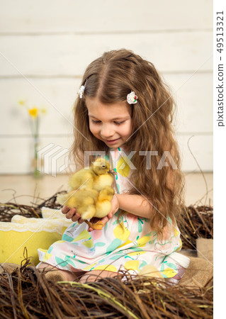 happy little girl in a dress sits in a nest and happy little girl in a dress sits in a nest and 49513321