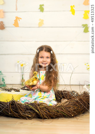 happy little girl in a dress sits in a nest and 49513325