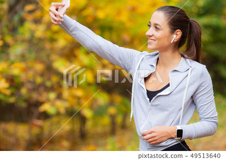 Sporty young girl with phone and headphones take selfie photo 49513640