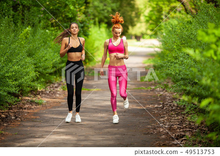 Runners training outdoors working out in the park Runners training outdoors working out in the park 49513753