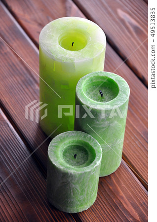 Green tubular candles on the wooden background Green tubular candles on the wooden background 49513835