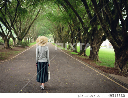woman take a walk on the way under the trees 49515880
