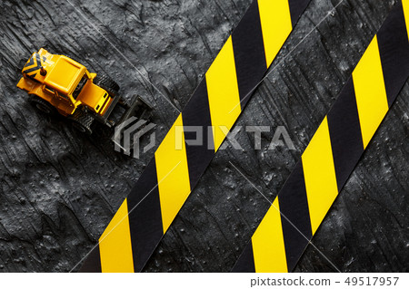 Yellow toy bulldozer on a black background Yellow toy bulldozer on a black background 49517957