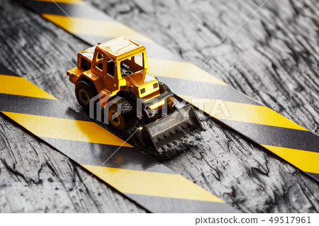 Yellow toy bulldozer on a black background 49517961