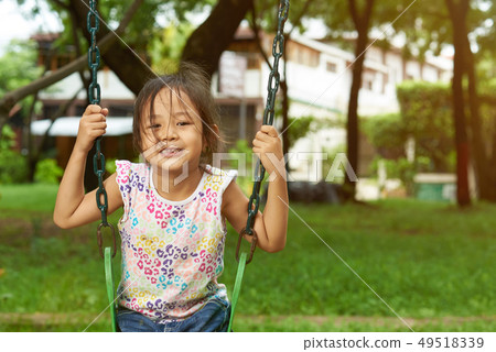 Asian girl on a swing hair on face Asian girl on a swing hair on face 49518339