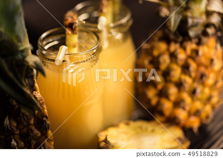 Pineapple juice and slice placed on a wooden table 49518829