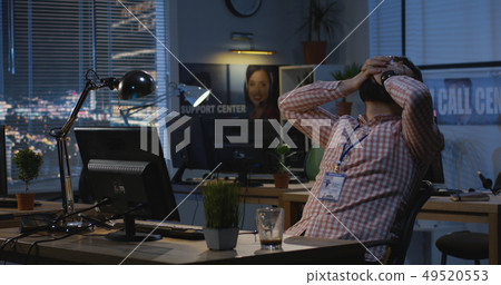 Man working late at night in an office 49520553