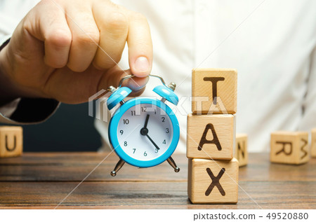 Businessman's hand holding a clock. Tax Businessman's hand holding a clock. Tax 49520880