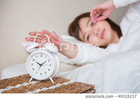 Woman getting up with an alarm clock (focus on the clock) 49528157