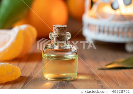 A bottle of tangerine essential oil with fresh 49528701