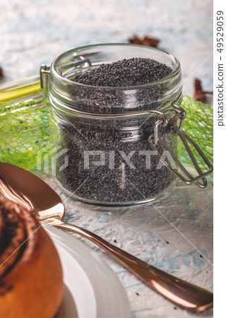 Glass jar with sealed cover full of raw poppy 49529059