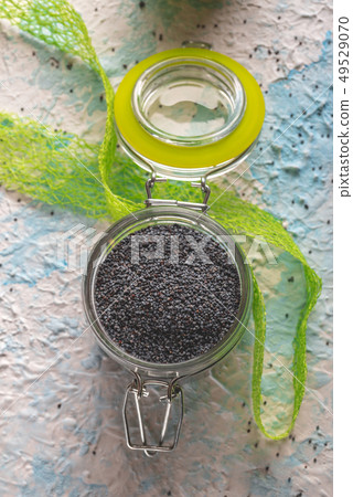 Glass jar with sealed cover full of raw poppy Glass jar with sealed cover full of raw poppy 49529070