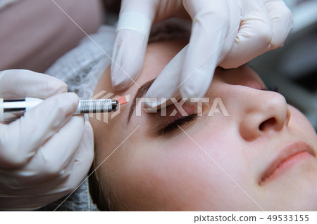 Permanent Makeup For Eyebrows. Microblading brow. Beautician Doing Eyebrow Tattooing For Female Face 49533155