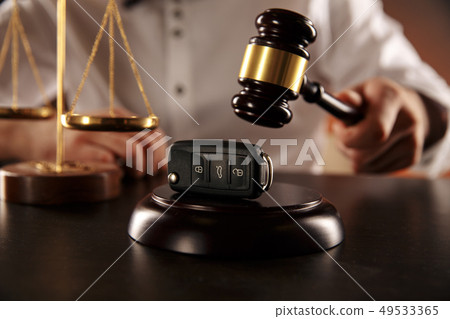 Close up of judge gavel and car keys over soundboard on white Close up of judge gavel and car keys over soundboard on white 49533365