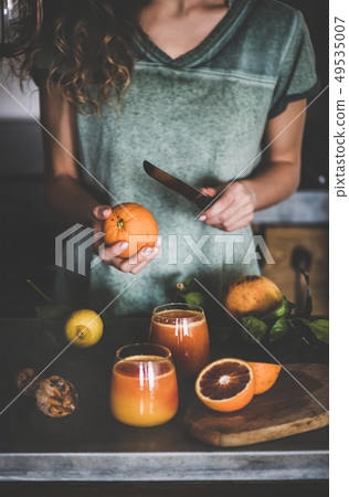Woman making fresh blood orange juice or smoothie 49535007