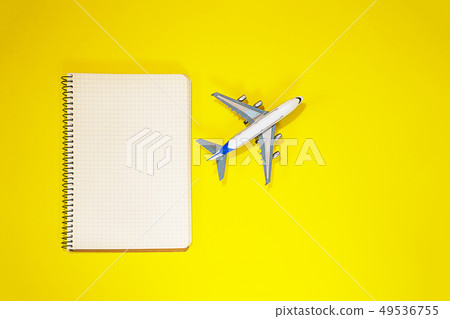 Minimal layout with model airplane, spiral notebook on yellow background. Directly above. Travel, Minimal layout with model airplane, spiral notebook on yellow background. Directly above. Travel, 49536755