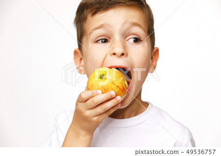 Little boy is eating apple studio shot Little boy is eating apple studio shot 49536757