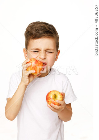 Little boy is eating apple with toothache 49536857
