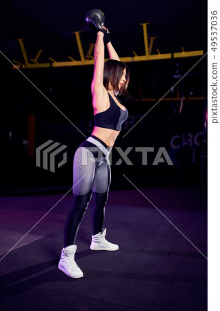 Attractive fit middle age womanathlete performing a kettle-bell swing 49537036