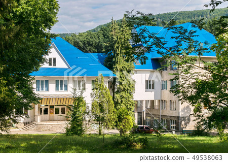 The building is white with a bright blue roof, aga The building is white with a bright blue roof, aga 49538063