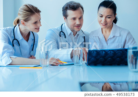 Competent doctor explaining situation to his assistants 49538173