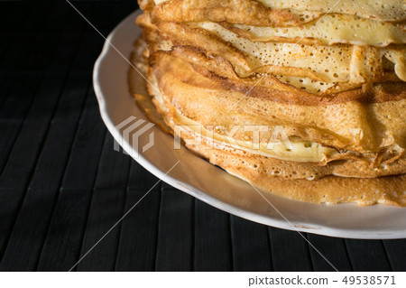 Stack of English pancakes on a round white plate 49538571