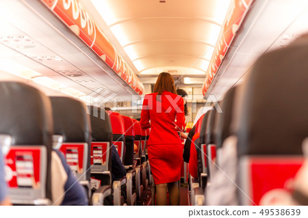 Flight attendant serve food and drinks to passengers on board. 49538639