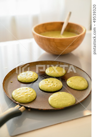 Pouring spinach pancake batter to frying pan 49539320