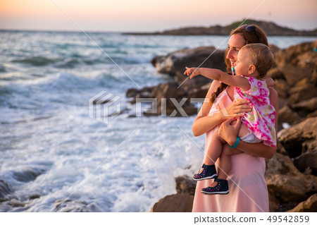 Mother and baby having fun at sunset beach 49542859