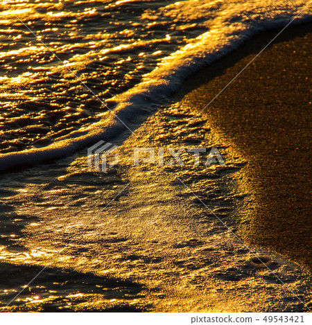 Abstract shapes of breaking waves on sandy shore 49543421