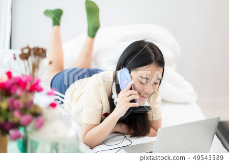 Young asia woman talking on cellphone while lying 49543589