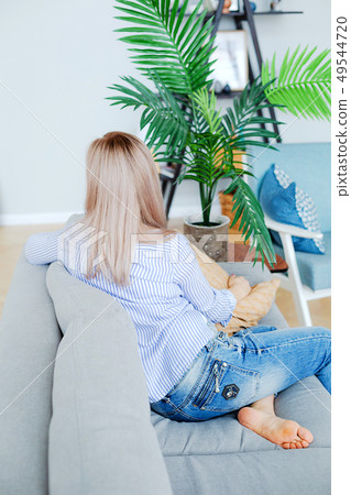 Blond young girl with long hair in a cozy interior 49544720