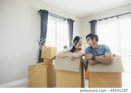 Happy young couple enjoying together moving in a Happy young couple enjoying together moving in a 49545397