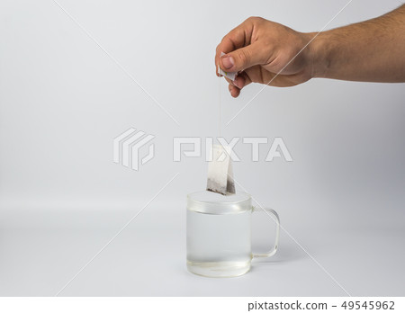 hand with tea bag and glass cup  49545962