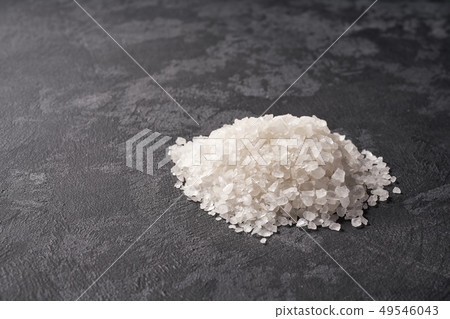 Heap of white salt on black stone background, with 49546043