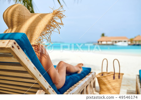 Woman at beach on wooden sun bed loungers 49546174