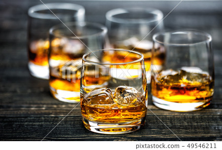 whiskey with ice on a black wooden background 49546211