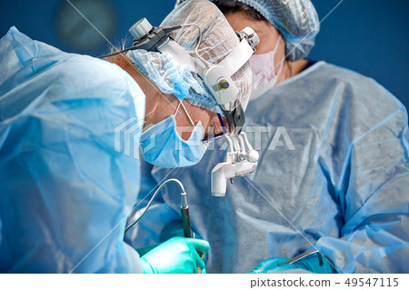 Team of surgeons makes an invasive operation. Portrait of surgeons close-up. Work with a coagulating Team of surgeons makes an invasive operation. Portrait of surgeons close-up. Work with a coagulating 49547115